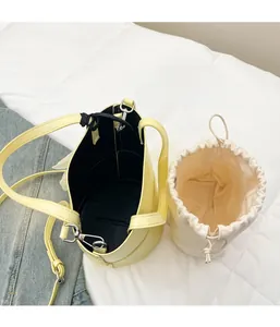 Detail view of the yellow leather bucket bag with a cream canvas drawstring inner pouch