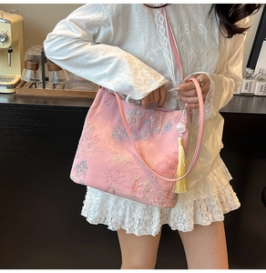Detail of pink silk tote bag with traditional embroidery and yellow silk tassel charm