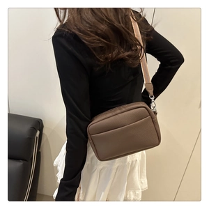 Detail view of brown lychee grain camera bag featuring a trendy colorful fabric wide strap