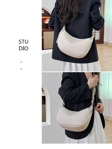 Detail view of cream lychee texture leather hobo bag with wide strap and gold hardware
