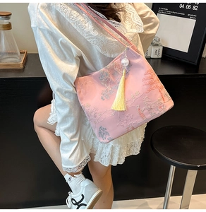 Detail of pink embroidered bucket bag with classical Chinese patterns and yellow tassel