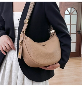 Detail of lychee pattern leather dumpling bag with adjustable geometric patterned strap