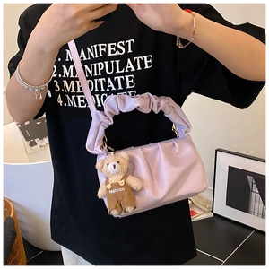 Purple pleated cloud shoulder bag with a teddy bear pendant on a casual outfit