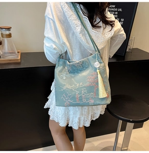 Detail of light blue bucket bag with traditional Chinese embroidery and silk tassel