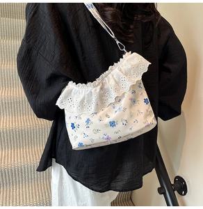 Detail view of floral crossbody bag featuring delicate lace trim and dainty blue flower patterns
