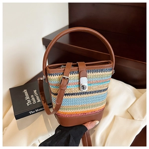 Detailed shot of multi-color woven bucket bag with leather handle and metal twist lock