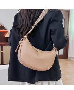 Detail of apricot crescent bag featuring lychee texture and jacquard woven strap