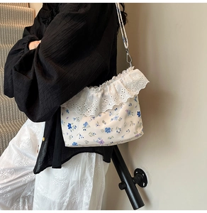 Close-up of floral shoulder bag with lace trim detailing and delicate flower pattern