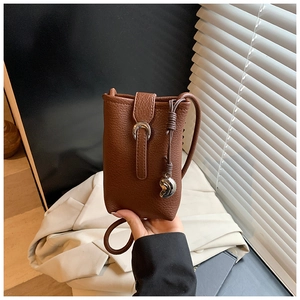 Détail d'un sac à bandoulière marron pour téléphone avec boucle en métal argenté et sangle