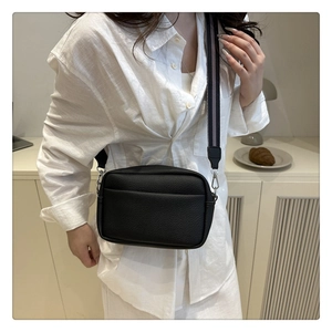 Litchi texture black PU crossbody bag styled with a striped wide shoulder strap