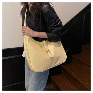 Detail view of large cream leather tote bag with stylish vertical straps and metal buckle