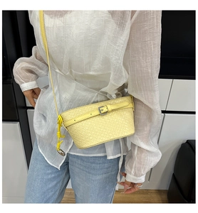 Dettaglio della mini borsa a tracolla intrecciata giallo pallido con nodo su modella