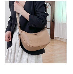 Detail of camel leather dumpling bag with textured grain and wide woven strap