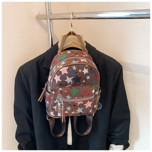 Detail of colorful star pattern on brown canvas backpack with multi-pocket structure