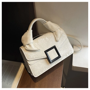 Détail du sac beige en similicuir serpent avec poignée nouée et boucle noire