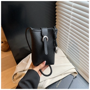 Detail of black pebbled leather bucket bag with silver horse-hoof buckle and knot strap