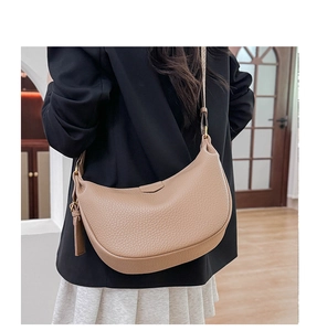Detailed back view of a beige crescent crossbody bag with lychee texture and gold buckle