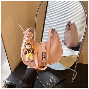 Detail of pink lychee leather dumpling bag with pearl charm and silver twist lock