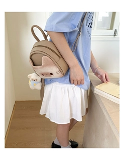 Detailed view of mini brown backpack with 3D cat toast pocket and plush puppy charm
