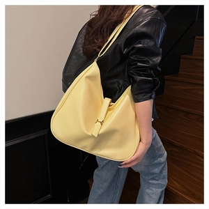 Detailed view of cream hobo shoulder bag with metal buckle on a model for daily commute
