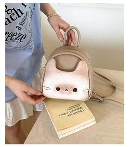 Close-up of the cute cat face embroidery on the khaki PU leather mini backpack details