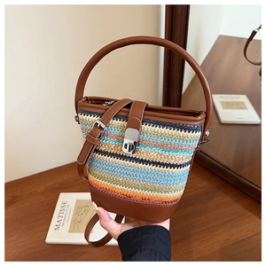 Detail of colorful rainbow woven bucket bag with brown leather base and silver twist lock