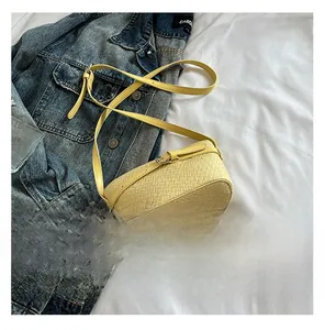 Dettaglio della trama in pelle intrecciata giallo chiaro su una borsa a tracolla quadrata