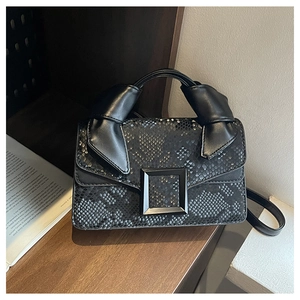 Détail du sac carré noir effet serpent avec grande boucle et poignée nouée élégante