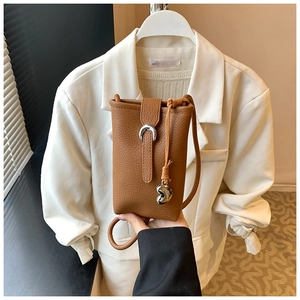 Close-up of brown litchi pattern bucket bag with silver crescent buckle and heart charm