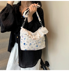 Detail of floral canvas bag with delicate lace trim and silver metal strap hooks
