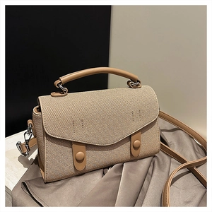 Detail of khaki woven texture and leather trim on this elegant mini crossbody bag