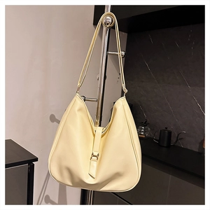 Detailed macro view of cream PU leather hobo bag with a vertical strap and gold buckle