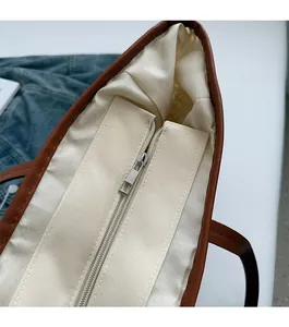 Vue détaillée du dessus d'un grand sac cabas en paille avec bordure cuir et fermeture éclair