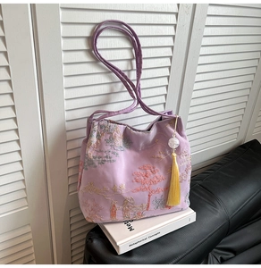Detail of light purple embroidered bucket bag with classical scenery and silk tassels