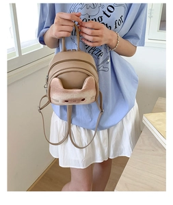 Close-up of khaki leather cat-shaped mini backpack with 3D flocked kitten face detail