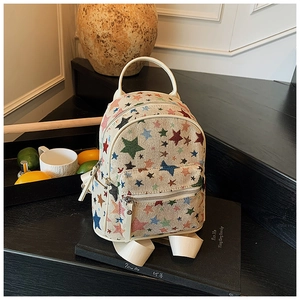 Detail of canvas mini backpack with colorful star embroidery and front zipper pocket