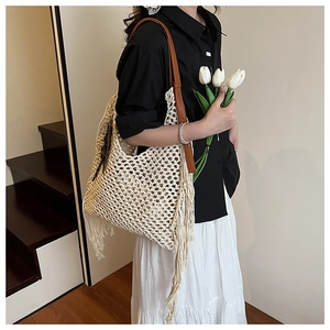 Détail du sac fourre-tout beige tissé à la main avec de longues franges et bandoulière en cuir