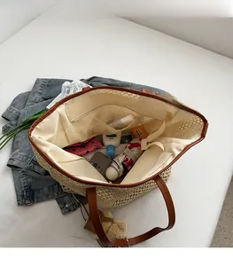 Vue macro du compartiment intérieur spacieux du sac cabas en paille avec bordure brune