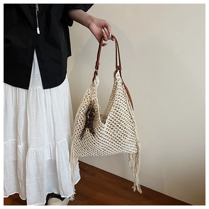 Détails du motif au crochet avec franges et chaîne en résine sur un sac crème