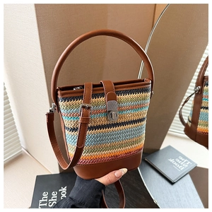 Detail showing colorful rainbow straw bucket bag with leather trim and round handle