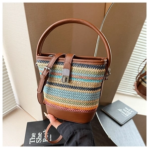 Close-up of bohemian rainbow woven bucket bag with brown leather trim and silver twist lock