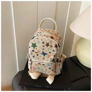 Detailed view of beige canvas backpack with colorful star embroidery and textured straps