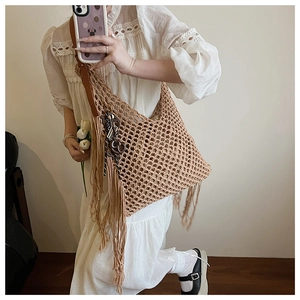 Détail d'un sac au crochet avec de longues franges et une bandoulière en cuir brun