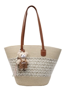 Woven straw tote bag with white mesh detail and cute brown bear charm accessory