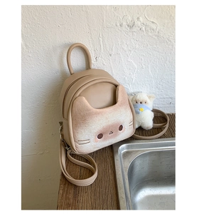 Detail of cartoon cat mini backpack in khaki PU leather with top handle and bear charm