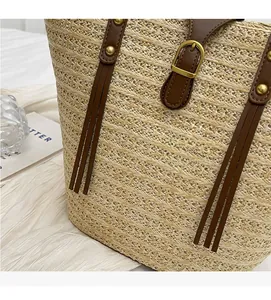 Detail of straw woven texture with dark brown leather strap and golden buckle buckle