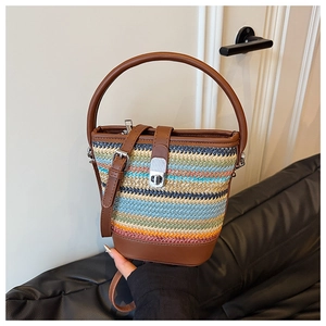 Detail of colorful rainbow woven straw bucket bag with leather strap and metal clasp