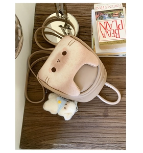 Detail of cute cat-shaped mini backpack with plush embroidery and bear keychain accessory