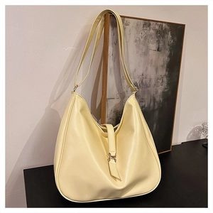 Detail view of large cream hobo bag with sleek leather texture and metal buckle ring