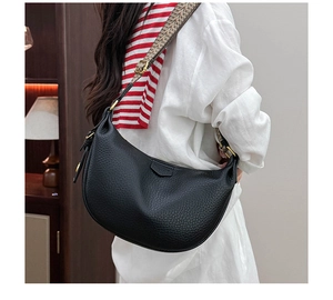 Detailed side view of black pebble leather hobo bag with ethnic style colorful woven strap